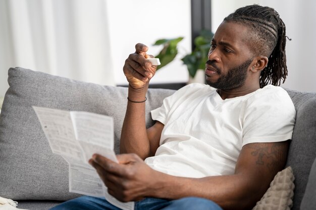 Hombre leyendo las instrucciones para una prueba de covid en casa