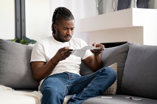 Hombre leyendo las instrucciones para una prueba de covid en casa