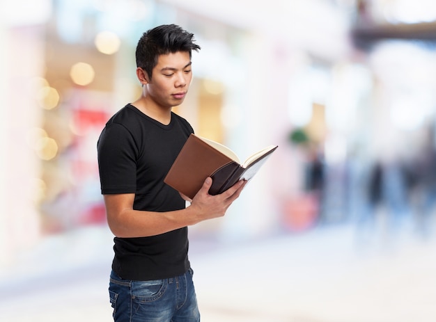 Hombre leyendo un libro con cara seria