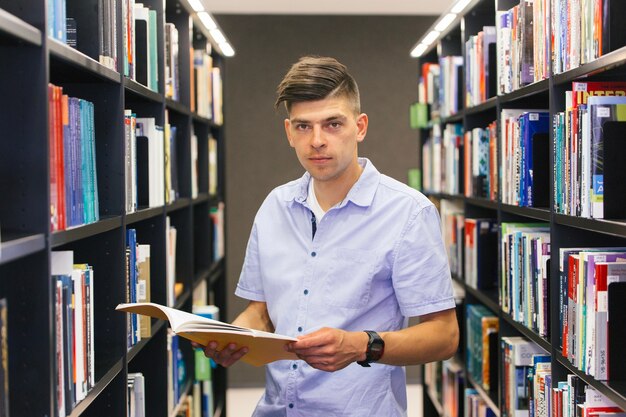 Hombre con libro entre estantes