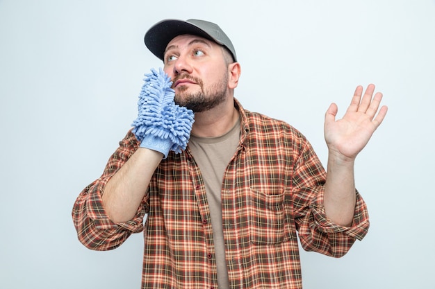 Foto gratuita hombre limpiador eslavo impresionado con guante de limpieza de microfibra y mirando al lado