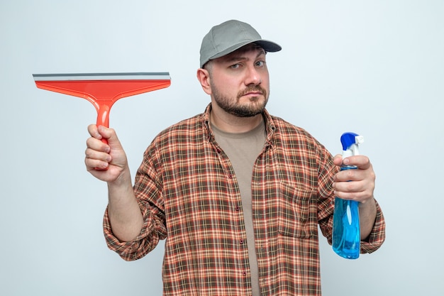 Hombre limpiador impresionado con escobilla de goma y limpiador en aerosol