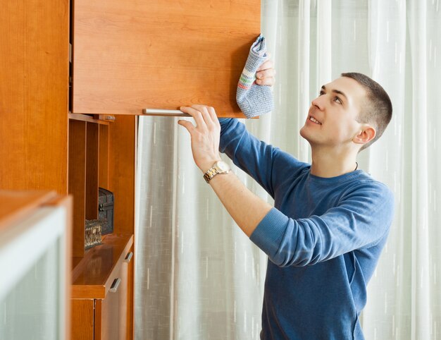 hombre limpiando muebles de madera