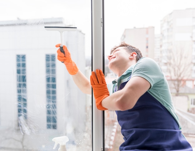 Foto gratuita hombre limpiando ventanas