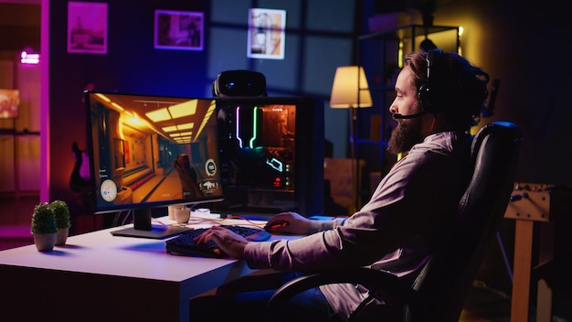 Hombre llegando a la sala de juegos listo para jugar a un videojuego de ciencia ficción en la PC con sus amigos