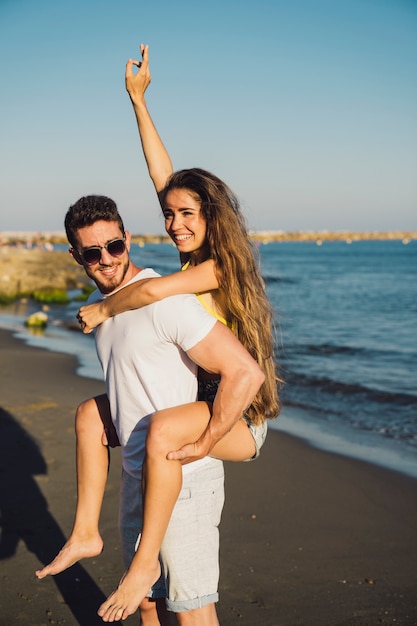 Foto gratuita hombre llevando chica por la playa