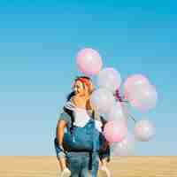 Foto gratuita hombre llevando a mujer alegre con globos