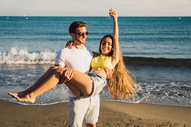 Hombre llevando su novia por la playa