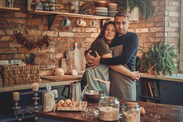 Un hombre maduro y atractivo pasa la mañana con su esposa en la cocina.