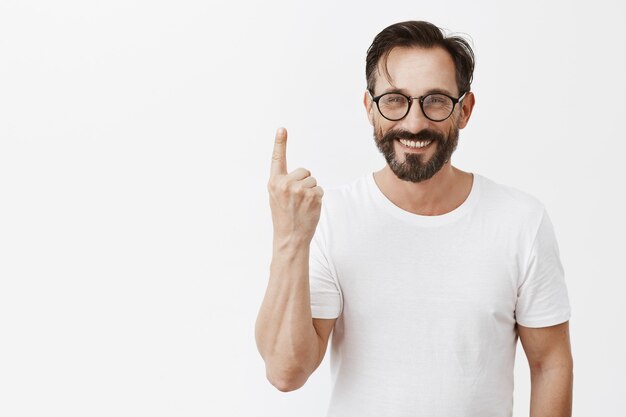 Hombre maduro barbudo feliz guapo con gafas posando