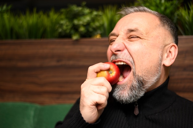 Hombre maduro comiendo una manzana