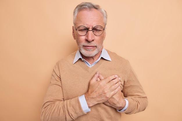 Hombre maduro estresado toca el pecho sufre de un infarto
