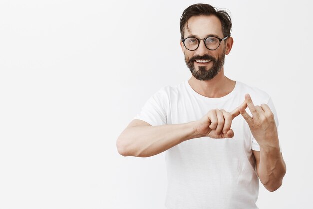 Hombre maduro guapo con barba con gafas posando