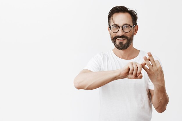 Hombre maduro guapo con barba con gafas posando