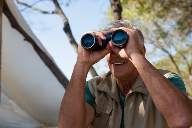 Hombre maduro mirando a través de binoculares