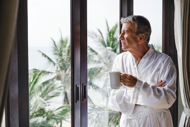 Hombre maduro mirando por la ventana del hotel