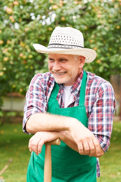 Hombre maduro sonriente durante el trabajo de jardinería