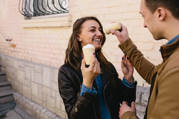 Hombre manchando la nariz de mujer con un helado