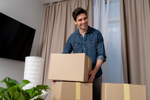 Hombre manejando pertenencias después de mudarse a un nuevo hogar