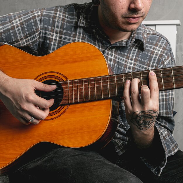 Hombre manos tocando la guitarra acústica