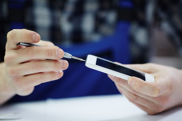 Hombre de mantenimiento abriendo teléfono inteligente