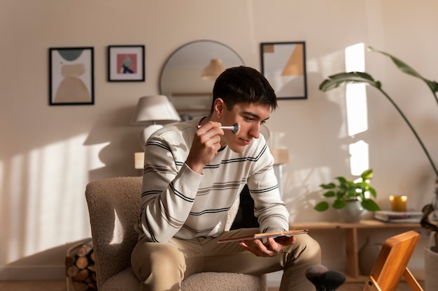 Foto gratuita hombre maquillándose en el interior