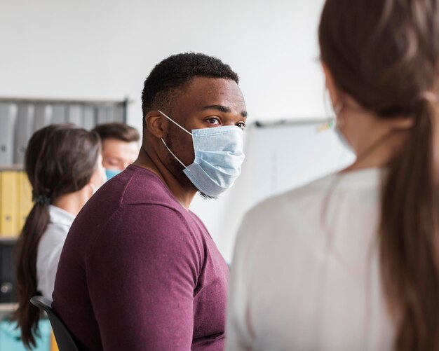 Hombre con máscara médica trabajando en la oficina durante la pandemia