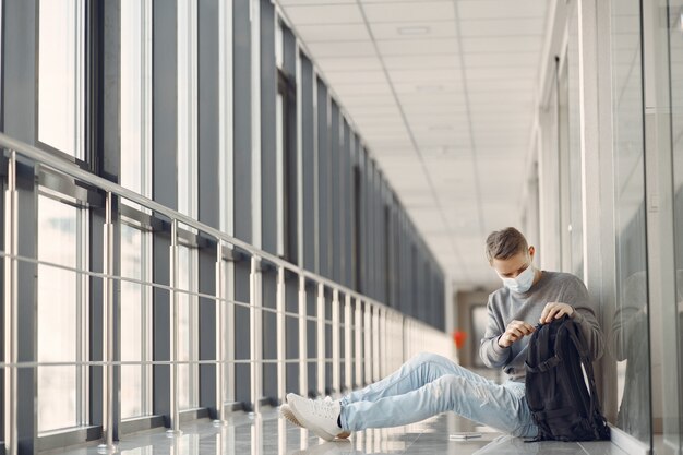 Hombre con una máscara sentada en el pasillo del hospital