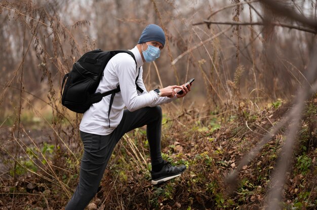 Hombre con mascarilla en el bosque