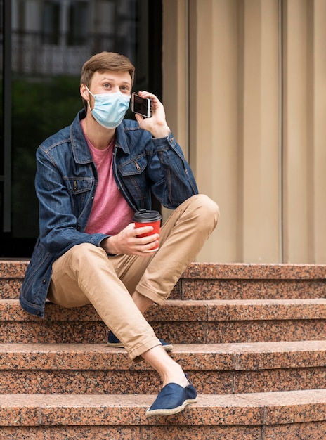 Foto gratuita hombre con mascarilla hablando por teléfono