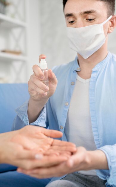 Hombre con mascarilla manos desinfectantes