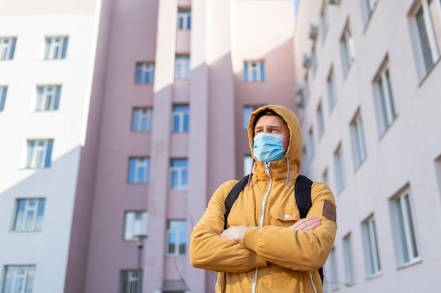 Foto gratuita hombre con mascarilla quirúrgica al aire libre