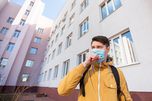 Foto gratuita hombre con mascarilla quirúrgica al aire libre