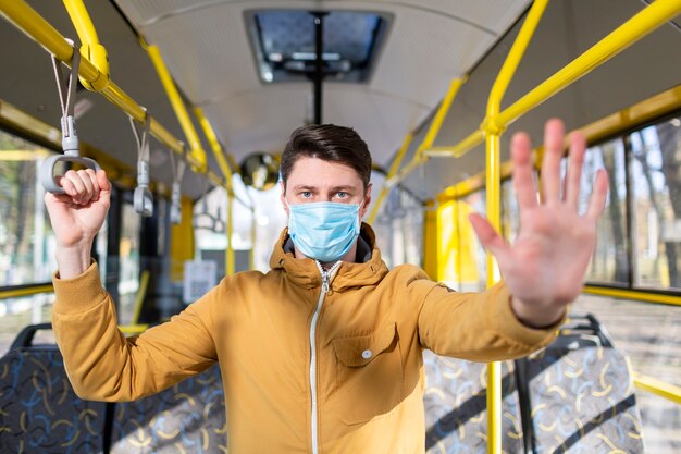 Hombre con mascarilla quirúrgica en transporte público