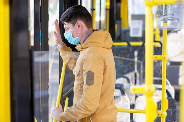 Hombre con mascarilla quirúrgica en transporte público