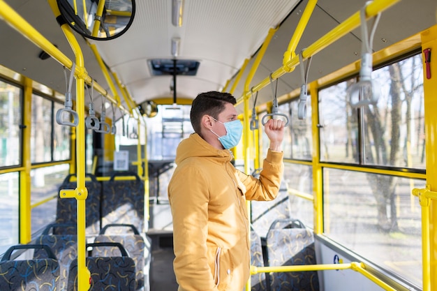 Hombre con mascarilla quirúrgica en transporte público