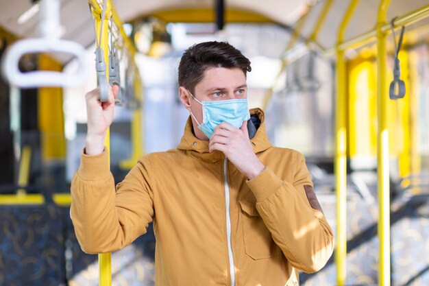 Hombre con mascarilla quirúrgica en transporte público