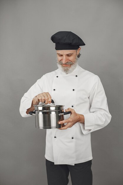 Hombre mayor con bandeja de metal. Chef con sombrero negro. Enfoque profesional de los negocios.