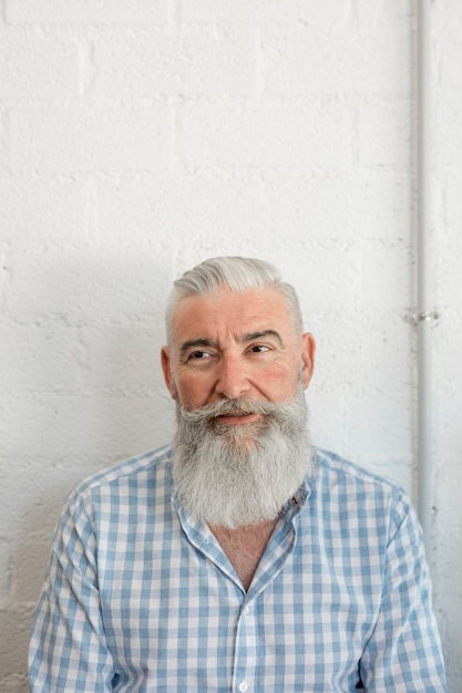 Foto gratuita hombre mayor barbudo de moda en camisa en salón