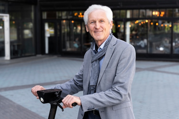 Hombre mayor en la ciudad con scooter eléctrico