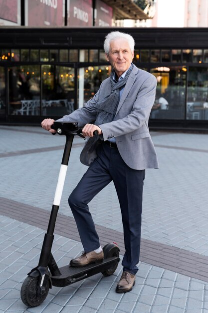 Hombre mayor en la ciudad con scooter eléctrico