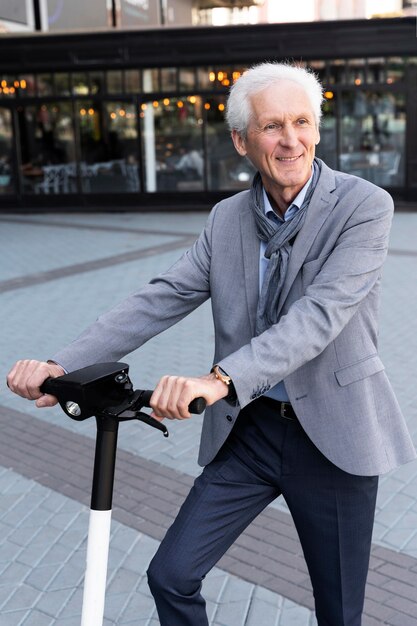 Hombre mayor en la ciudad con scooter eléctrico