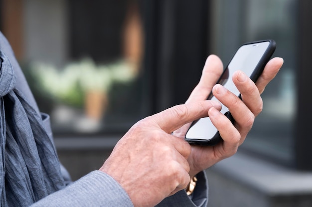 Hombre mayor en la ciudad con smartphone