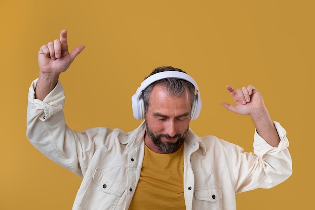 Foto gratuita hombre mayor, escuchar música, por, auriculares