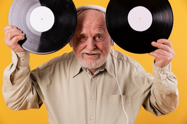 Foto gratuita hombre mayor juguetón con discos de música