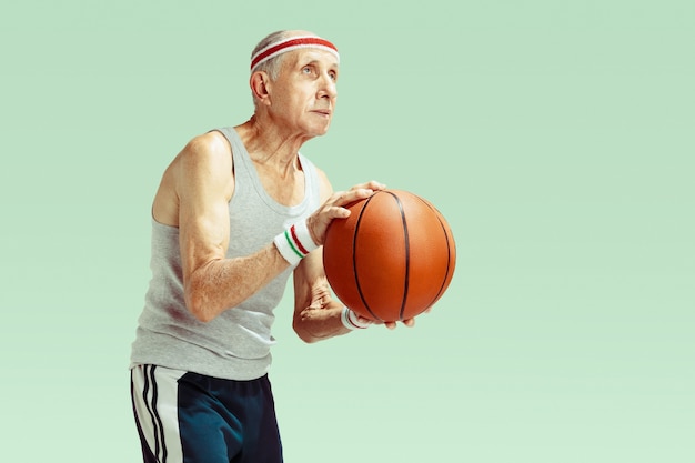 Hombre mayor, llevando, ropa deportiva, jugar al básquetbol, en, verde