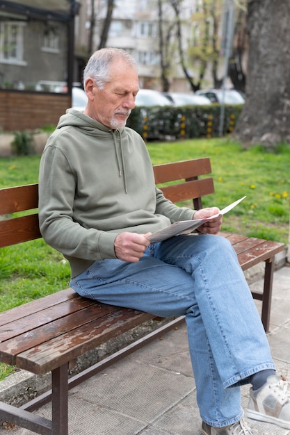 Hombre mayor moderno leyendo el periódico