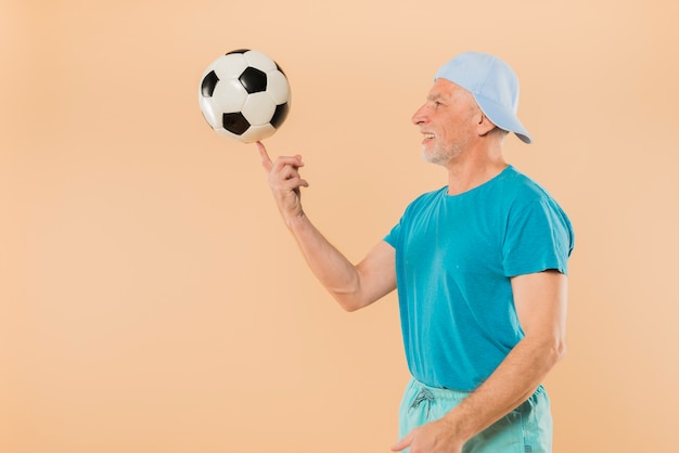 Hombre mayor moderno con pelota de fútbol