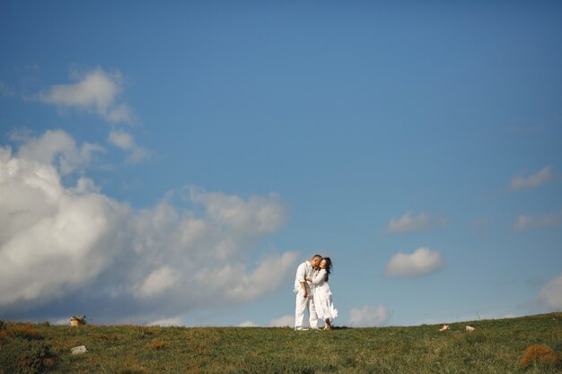 Hombre mayor y mujer en las montañas. Pareja adulta enamorada al atardecer. Hombre con camisa blanca.