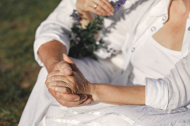 Hombre mayor y mujer en las montañas. Pareja adulta enamorada al atardecer. Hombre con camisa blanca.